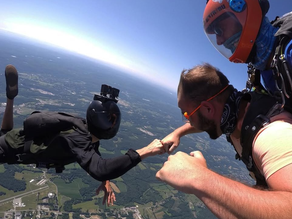 camerafistbump960x720 tandem skydivers exit the aircraft over sussex, NJ while the instructor smiles at the camera